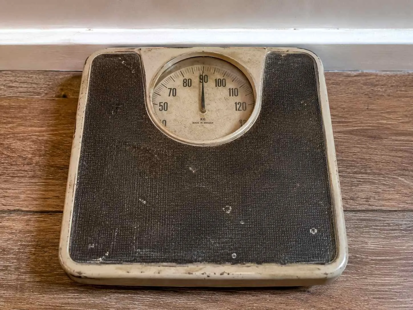 Vintage mechanische weegschaal met crèmekleurig kunststof behuizing en donkergrijs platform, schaal loopt van 0 tot 120 kilogram.